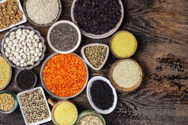 Tahta bir masanın üzerindeki tabakta çeşitli tahıl ve tahılların yemek arkaplanı.