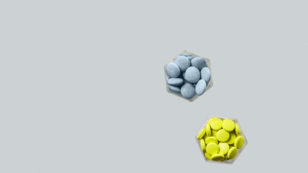 Різні таблетки і капсули в гексагональних банках з'являються на сірому фоні — стокове відео