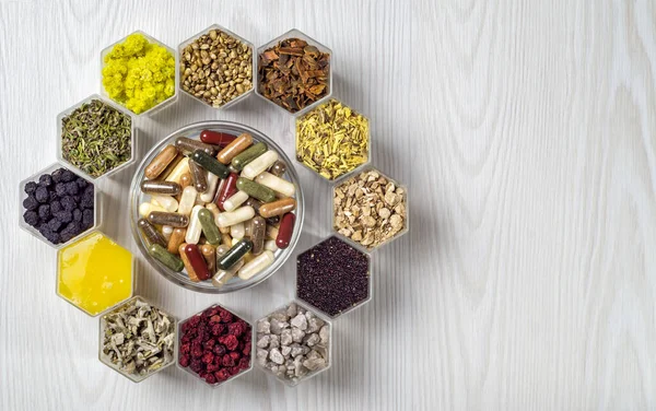 Altıgen kavanozlarda besin takviyeleri bulunan bitkisel ve mineral organik maddeler ve kapsüller bal peteği şeklindedir.