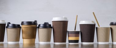 Tek kullanımlık kağıt kahve fincanları, farklı renk ve tasarımlarla kaplanmış.