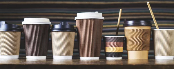 Disposable paper coffee cups with lids in different colors and designs