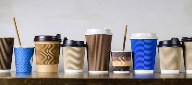 Tek kullanımlık kağıt kahve fincanları, farklı renk ve tasarımlarla kaplanmış.
