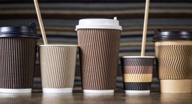 Tek kullanımlık kağıt kahve fincanları, farklı renk ve tasarımlarla kaplanmış.