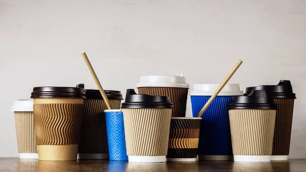 Disposable paper coffee cups with lids in different colors and designs