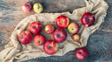 Tahta bir masada taze kırmızı elmalar.