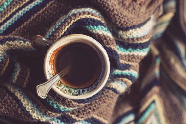 Sıcaklık konsepti. Bir fincan kahve ve sıcak yün atkı.