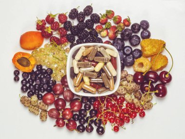 Beslenme takviyeli, vitaminli ve çeşitli taze meyveli kapsüller.