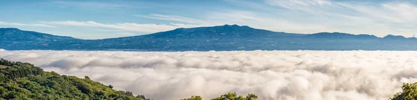 Panoramico delle montagne sopra le nuvole — Foto Stock