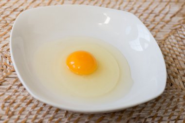 Beyaz bir plaka üzerinde çiğ yumurta