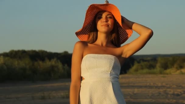 Девушка позирует на берегу в шляпе — стоковое видео