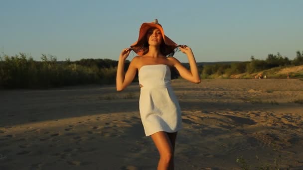 Chica posando en la orilla en un sombrero — Vídeo de stock