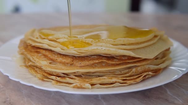 Pfannkuchen auf einem Teller sind mit Honig gefüllt — Stockvideo