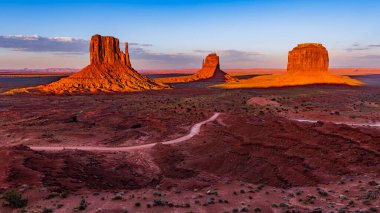 Batı ve Doğu Mitten Buttes (Mittens olarak da bilinir) Arizona 'daki Navajo Anıt Vadisi Kabile Parkı' nda güneşle aydınlanan iki kıç..