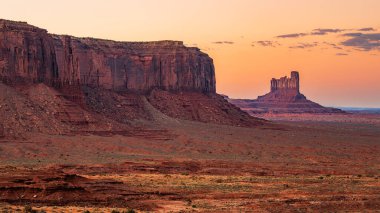 Batı ve Doğu Mitten Buttes Anıt Vadisi Navajo Kabile Parkı 'nda (ayrıca Mitten olarak da bilinir) alacakaranlıkta Utah' ta gün batımında.