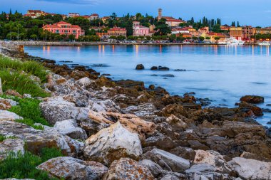 Adriyatik Denizi kıyısı ve St. Euphemia Kilisesi 'nin çan kulesi ve Hırvatistan' ın eski Rovinj kenti, Istria, alacakaranlık mavi bir saatte şafakta.