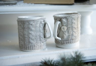 winter decor.Two cups in knitted covers 