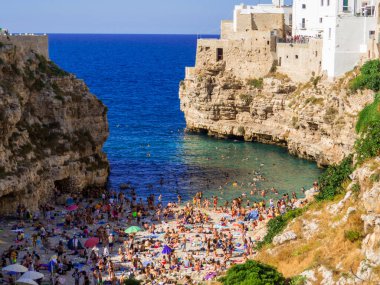 Polignano a Mare, İtalya - 6 Ağustos 2021: İnsanlar plajda.