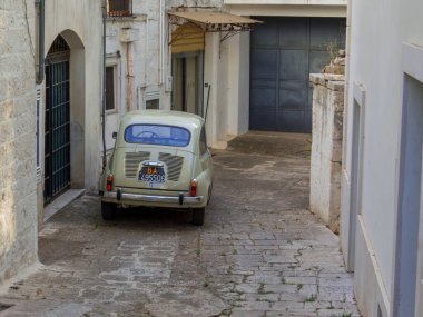 Locorotondo, İtalya - 8 Ağustos 2021: Geleneksel klasik İtalyan arabası Fiat 500 eski kasabaya park edildi.