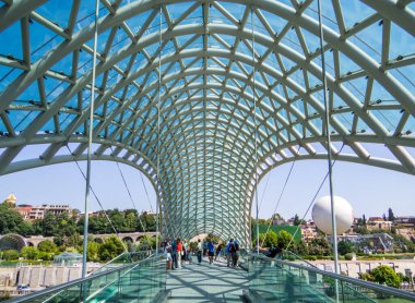 Tbilisi, Georgia - September 2, 2024: People on the Bridge of Peace crossing the Kura river.