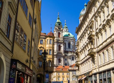 Prag, Çek Cumhuriyeti - 28 Nisan 2025: Arka planda Aziz Nicholas Kilisesi (Mala Strana) bulunan eski kentte Picturesque caddesi.