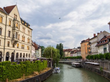Ljubljana, Slovenya - 6 Temmuz 2025: Eski kentteki Üçlü Köprü 'de (Tromostovje) görülen Ljubljanica Nehri manzarası.