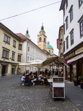 Ljubljana, Slovenya - 6 Temmuz 2025: Arka planda Aziz Nicholas Katedrali olan eski kentte Picturesque Caddesi.