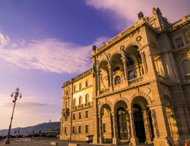 Trieste, İtalya - 7 Temmuz 2025: İtalya Meydanı 'nda gün batımında Avusturya Teğmenliği Sarayı' nın manzarası.