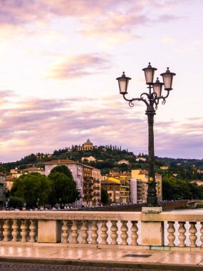Arka planda Lourdes leydisinin mabedi olan Adige Nehri 'nin güzel gün batımı manzarası