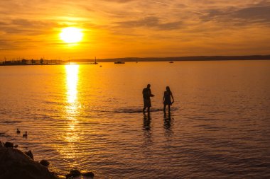 Siofok, Macaristan - 21 Eylül 2025: Balaton Gölü 'nde gün batımında insanlar.