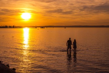 Siofok, Macaristan - 21 Eylül 2025: Balaton Gölü 'nde gün batımında insanlar.