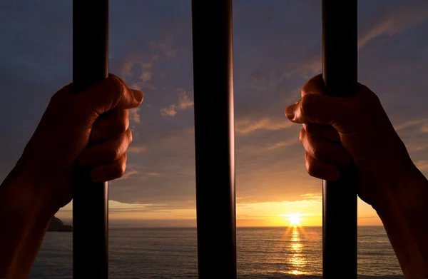 Τα χέρια του κρατούμενου με το ηλιοβασίλεμα στο παρασκήνιο — Φωτογραφία Αρχείου