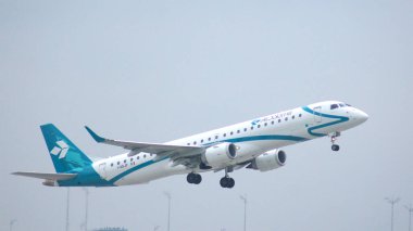 MUNICH, Almanya - 11 Ekim 2015: Air Dolomiti İtalyan havayollarının Embraer E-Jet E-Jet ERJ-195 uçağı Münih uluslararası yolcu havaalanından havalandı ve irtifa kazandı
