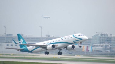 MUNICH, Almanya - 11 Ekim 2015: Air Dolomiti İtalyan havayollarının Embraer E-Jet E-Jet ERJ-195 uçağı Münih uluslararası yolcu havaalanından havalandı ve irtifa kazandı