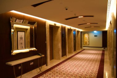 DUBAI, BİRLİK ARAB EMIRATES - 16 Haziran 2019: asansör lobisinin yanındaki lüks bir otelde uzun ve karanlık bir koridor