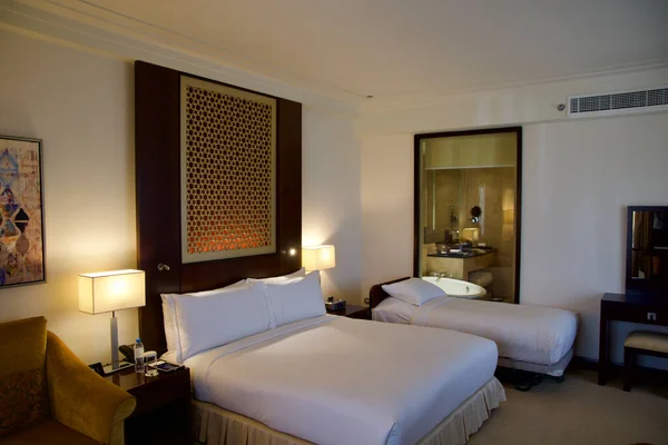 DUBAI, EMIRADOS ARAB UNIDOS - JUN 16, 2019: Quarto de hotel de luxo com cama e vista em casa de banho com decoração agradável — Fotografia de Stock