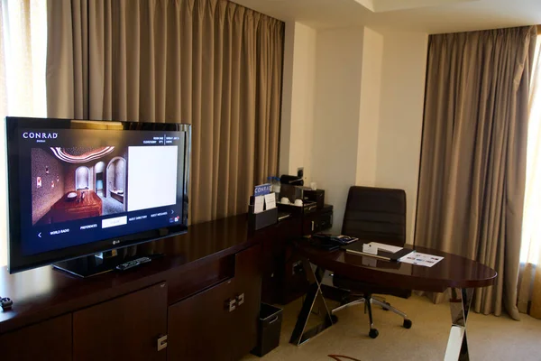 DUBAI, EMIRADOS ARAB UNIDOS - JUN 16, 2019: Uma mesa de trabalho em um luxuoso quarto de hotel de negócios com TV — Fotografia de Stock