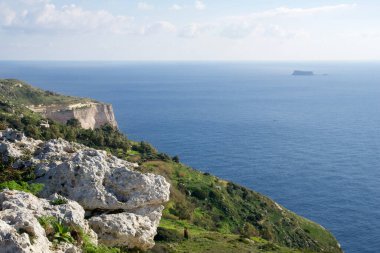 DINGLI CLIFFS, MALTA - 22 Ocak 2020: Arka planda Dingli Cliffs ve Fifla Island ile Malta Denizi kıyıları. Panoramik manzaralı yüksek manzaralı uçurumlar