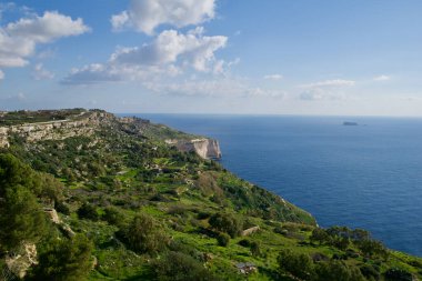 DINGLI CLIFFS, MALTA - 22 Ocak 2020: Arka planda Dingli Cliffs ve Fifla Island ile Malta Denizi kıyıları. Panoramik manzaralı yüksek manzaralı uçurumlar