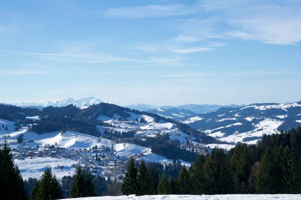 OBERSTAUFEN, GERMANY - 29 DEC, 2017: Bavyera Alplerinde yeşil kozalaklı ağaçlarla karla kaplı Oberstaufen kış spor merkezinin harika manzarası