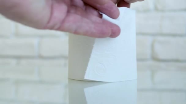 Mãos de uma pessoa no banheiro Tirando papel higiênico do rolo — Vídeo de Stock