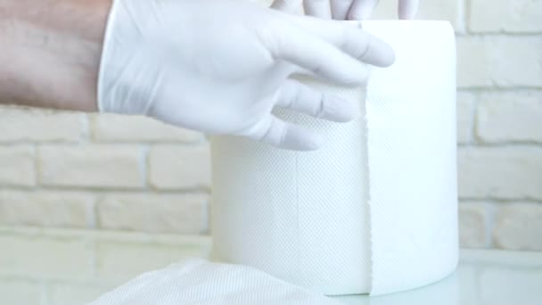 A empregada doméstica com luvas de proteção nas mãos tira toalhas de papel seco de um rolo usando-as para limpar superfícies molhadas — Vídeo de Stock