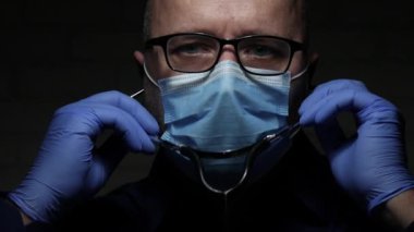 Bir Solunum Hastalığında Tıbbi Danışmanlık için Stetoskop kullanarak COVID-19 'a Karşı Yüz Maskesi ve Eldivenlerle Doktorla Yavaş Hareket