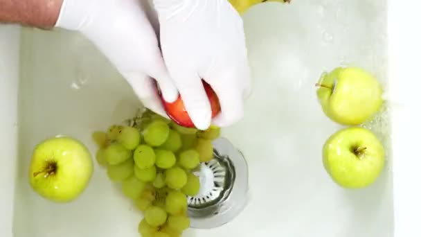 Mãos Usar Luvas de Proteção Lavar com Água Frutas Frescas em um Pia Branca na Cozinha — Vídeo de Stock