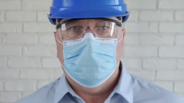 Портрет з інженером в захисній медичній масці для обличчя та шоломі безпеки — стокове відео