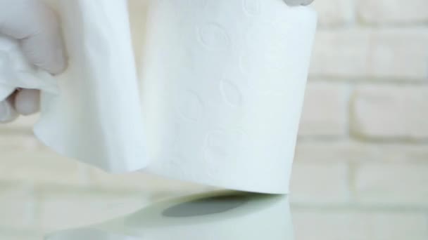 A Person in Bathroom  with Protective Gloves in Hands Takes Toilet Paper from a Paper Roll — Stock Video