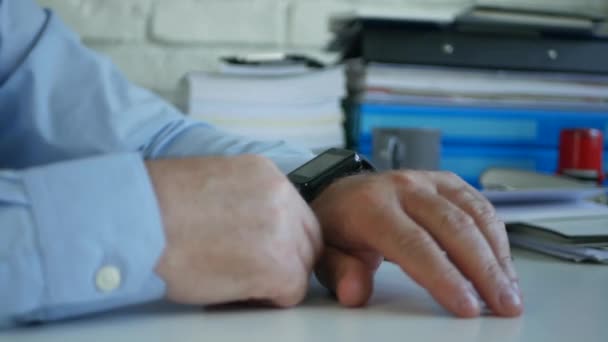 Imagem com um homem de negócios na sala de escritório usando seu Smartwatch de sua mão — Vídeo de Stock