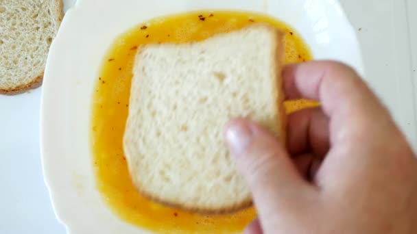 Man förbereda rostat ägg med skivor bröd och färska ägg blandas i en skål — Stockvideo
