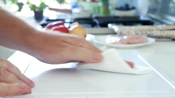 Hushållsarbete i köket, rengöring av bänkskivan med en vitbok servett — Stockvideo