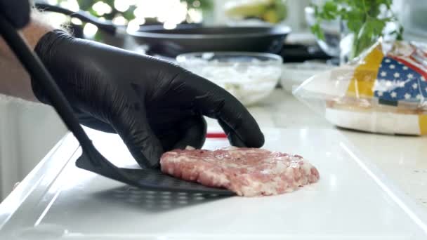 Mano de un hombre preparando en la cocina una hamburguesa con carne de res roja — Vídeo de stock