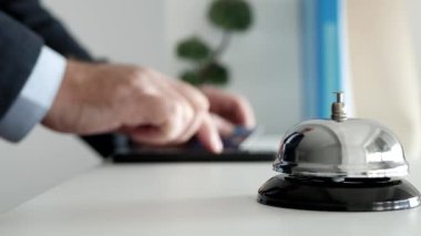 Kredi kartı ve cep telefonu ile çevrimiçi ödeme yapan bir otelin resepsiyonundaki turist